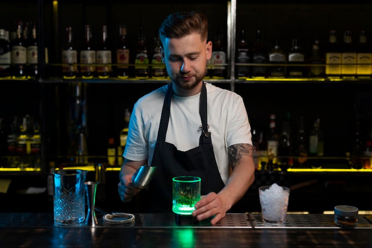 Barman przygotowujący drinka w mroku